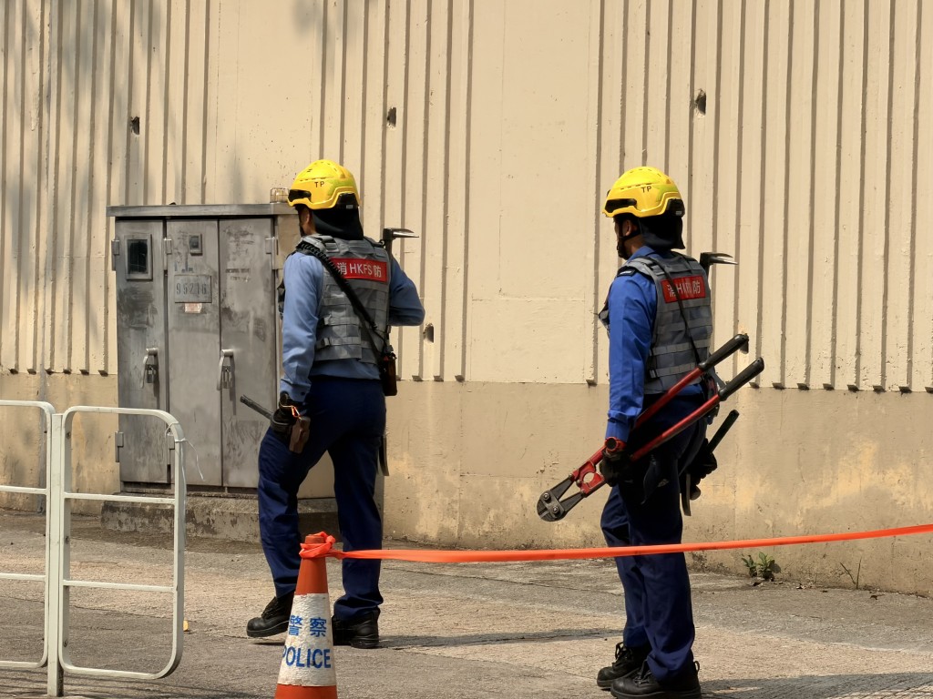 消防員帶備爆破工具上樓，協助居民。
