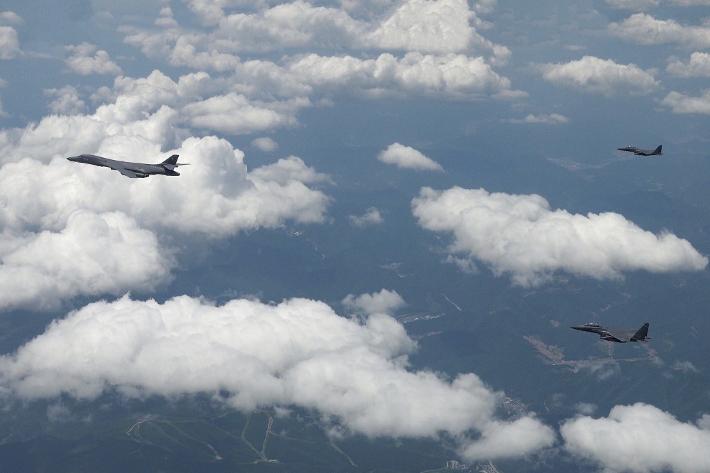 在韓美聯合空中演習期間，美國空軍B-1B轟炸機（左）和韓國戰鬥機F-15K飛越朝鮮半島。 南韓國防部