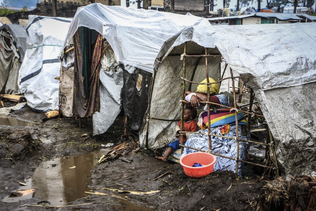 剛果一位母親帶著孩子暫住臨時搭建的簡陋棚屋。香港紅十字會提供