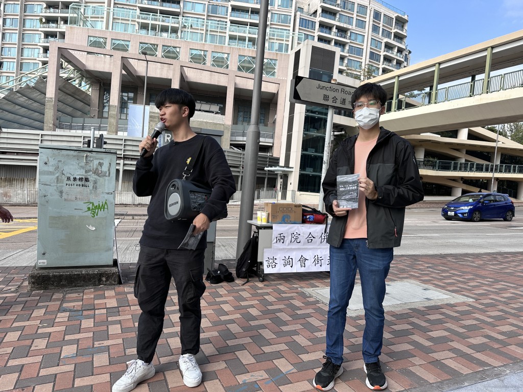 關注組日前於浸大校門外擺設街站及派發傳單，呼籲師生出席周四舉行的兩院合併諮詢會。