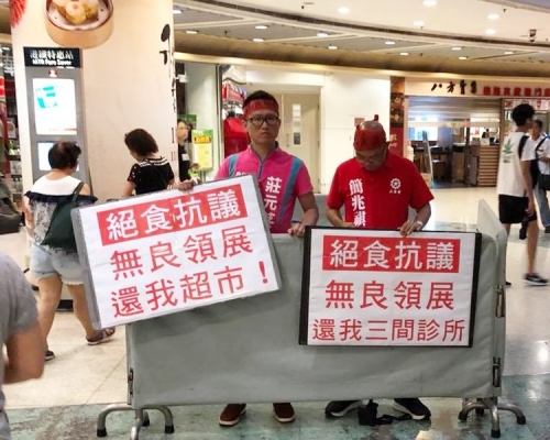 兩名區議員簡兆祺(右)及莊元苳,在商場內手持標語請願。Christopher Siu圖片