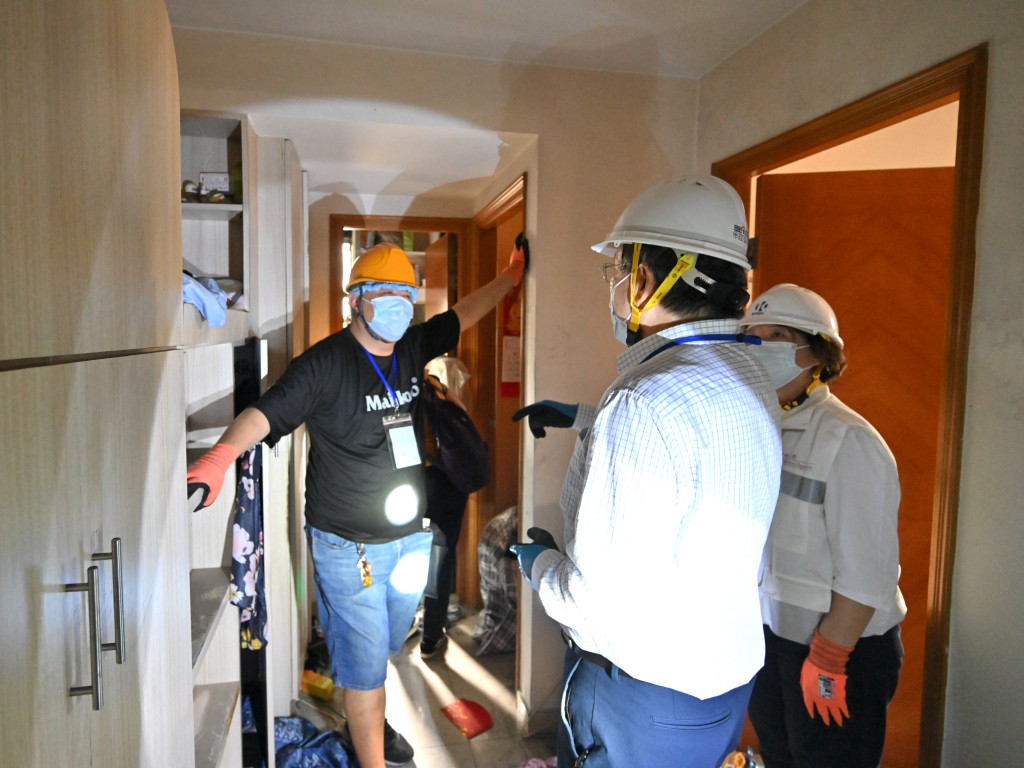 政務司副司長卓永興（中）今日到宏昌閣上樓，與回家執拾的居民傾談。