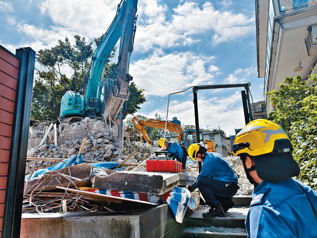 消防员赶至村屋砖墙倒塌现场进行拯救。