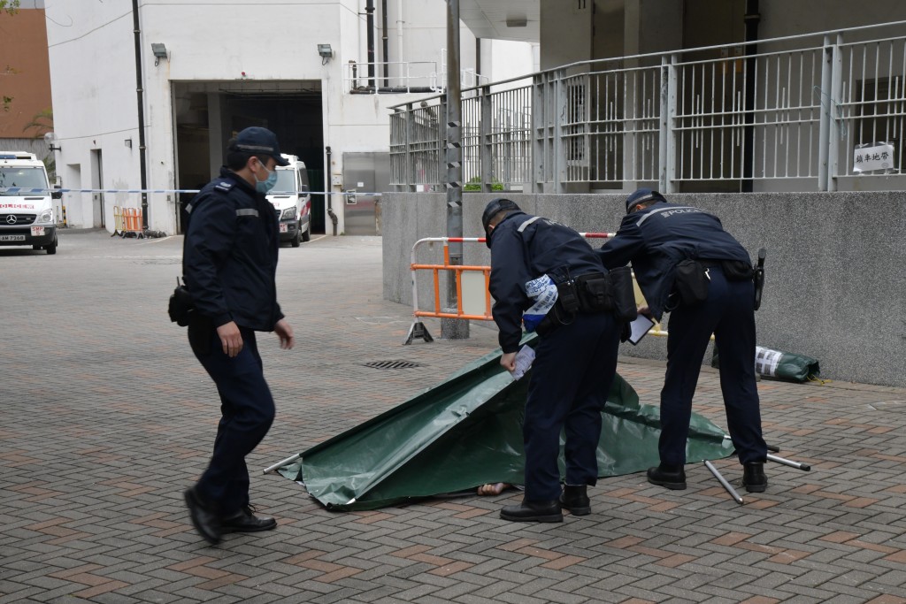 警員用綠帆布遮蓋屍體。