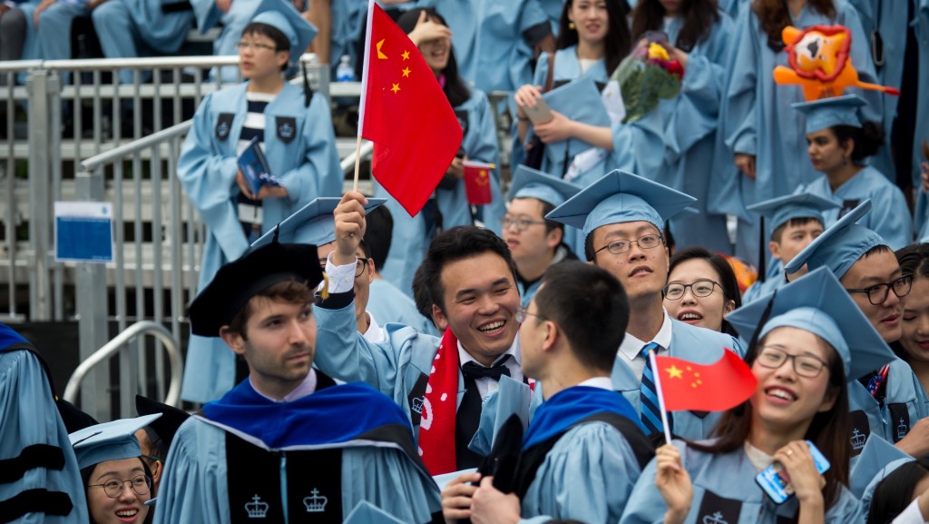 纽约哥伦比亚大学华人毕业生在毕业典礼上挥舞中国国旗。 新华社