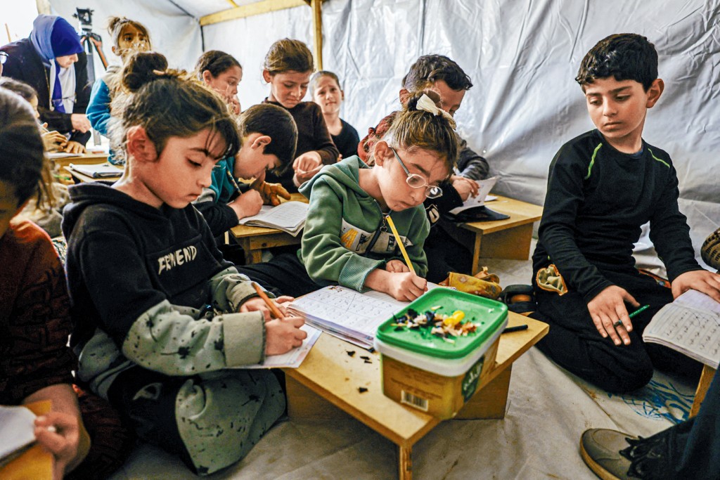 加沙南部拉法市的儿童在一个帐篷设立的临时课室上课。
