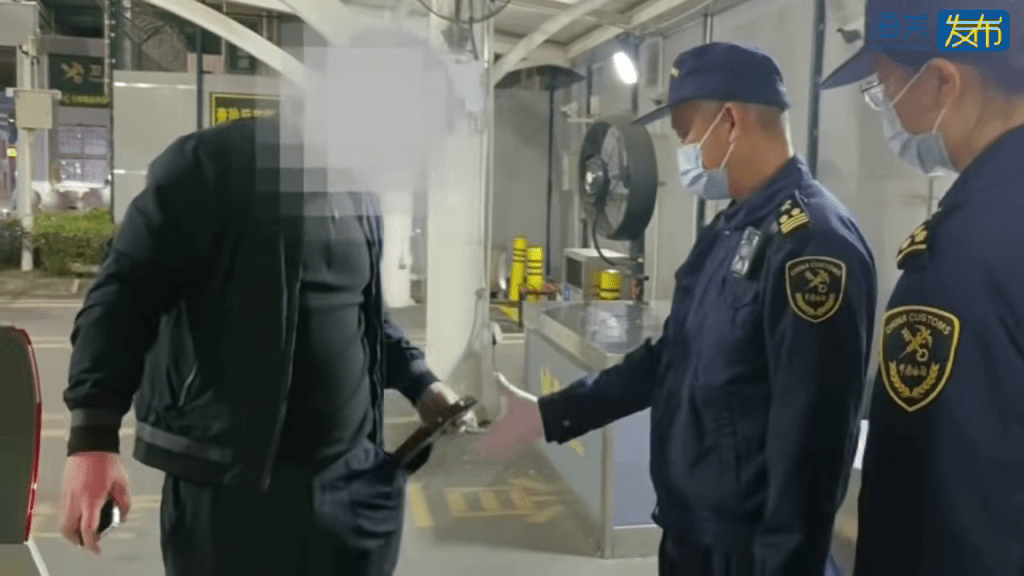 跨境司機在褲袋拿出黑色膠袋。海關發布