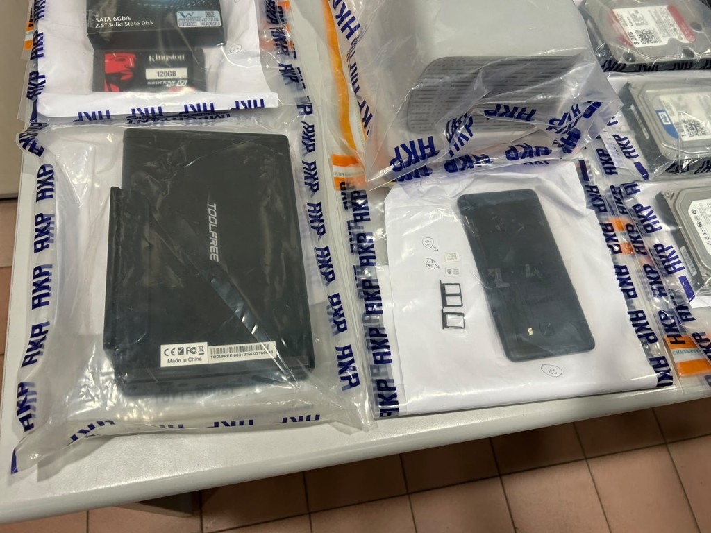 警方從被捕男子的寓所內撿取思疑與案有關的電腦設備。 警方從被捕男子的寓所內撿取思疑與案有關的電腦設備。