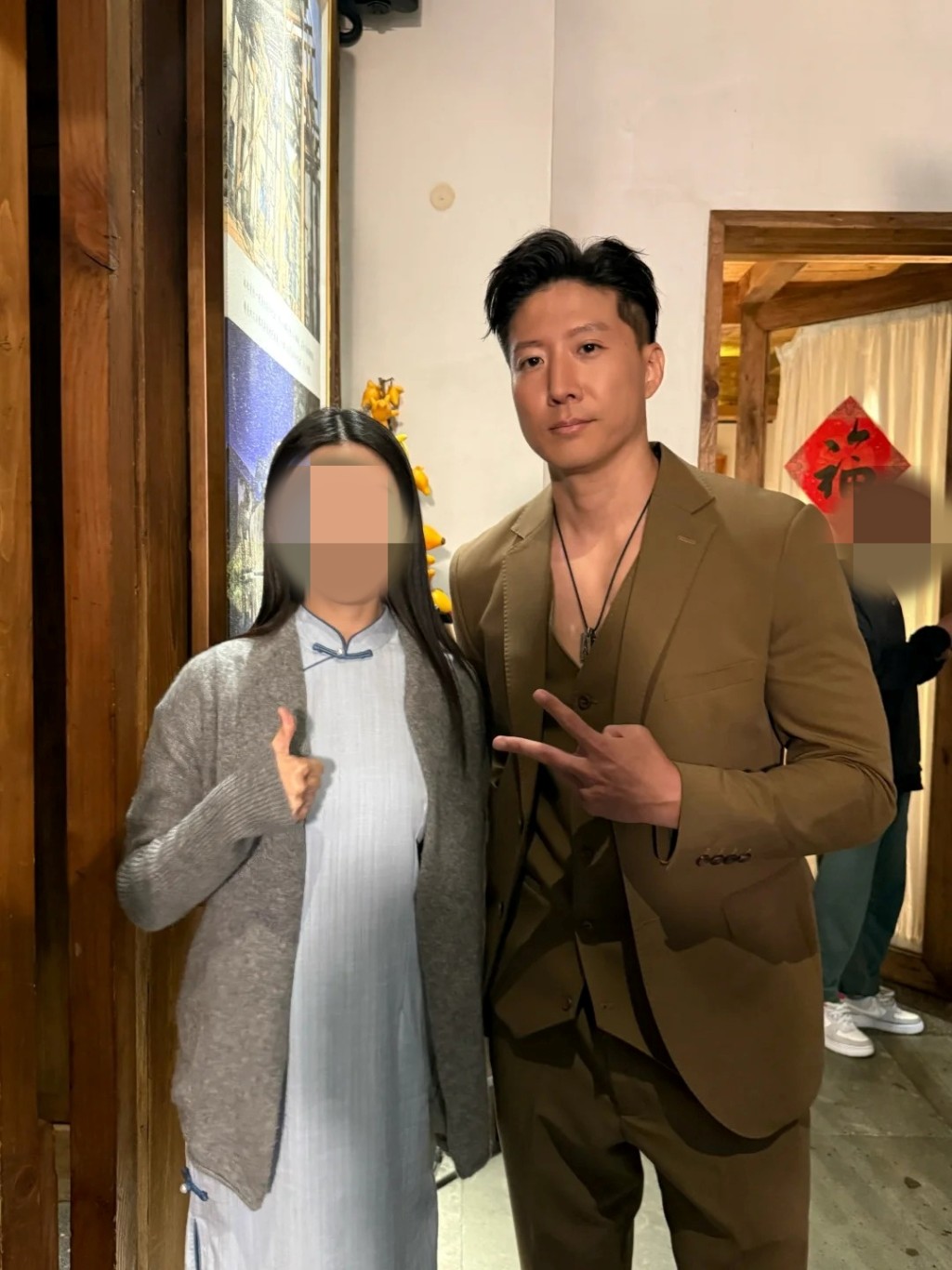 三子洪天照身穿啡色西裝高大筆挺，擺出V字手勢合照，外貌極似爸爸。