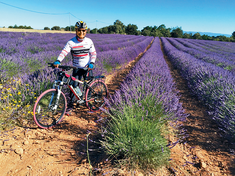 早年單車歐洲遊行程中，梁榮武於法國的花田留影。