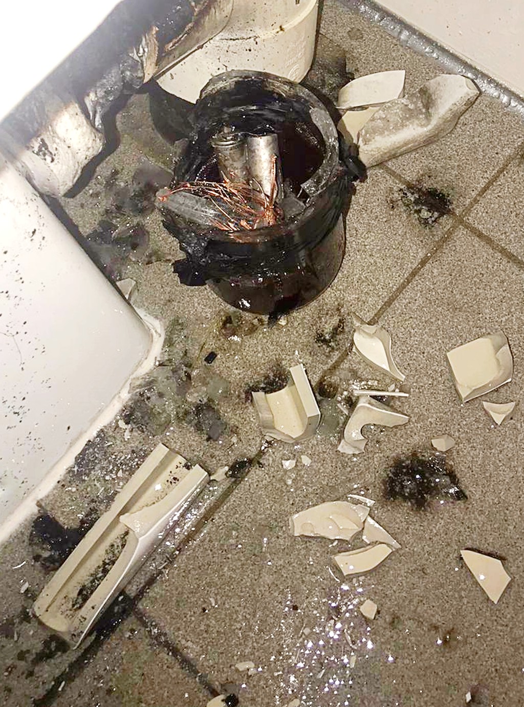 爆炸發生後,明愛醫院男廁馬桶後見碎片散落,玻璃瓶內見電池及見線等。 爆炸發生後,明愛醫院男廁馬桶後見碎片散落,玻璃瓶內見電池及見線等。