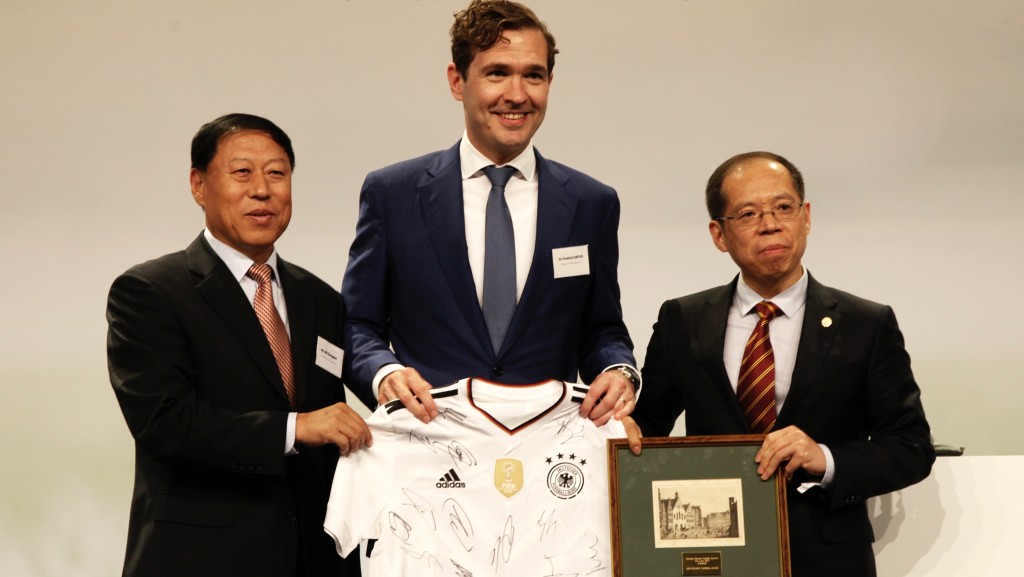首屆中德足球峰會在法蘭克福閉幕時，馬成全（左）代表中國足協接受德國國家隊全體成員簽名的球衣。 新華社