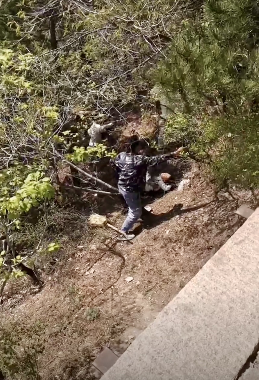 一名傷者倒臥在山坡上。