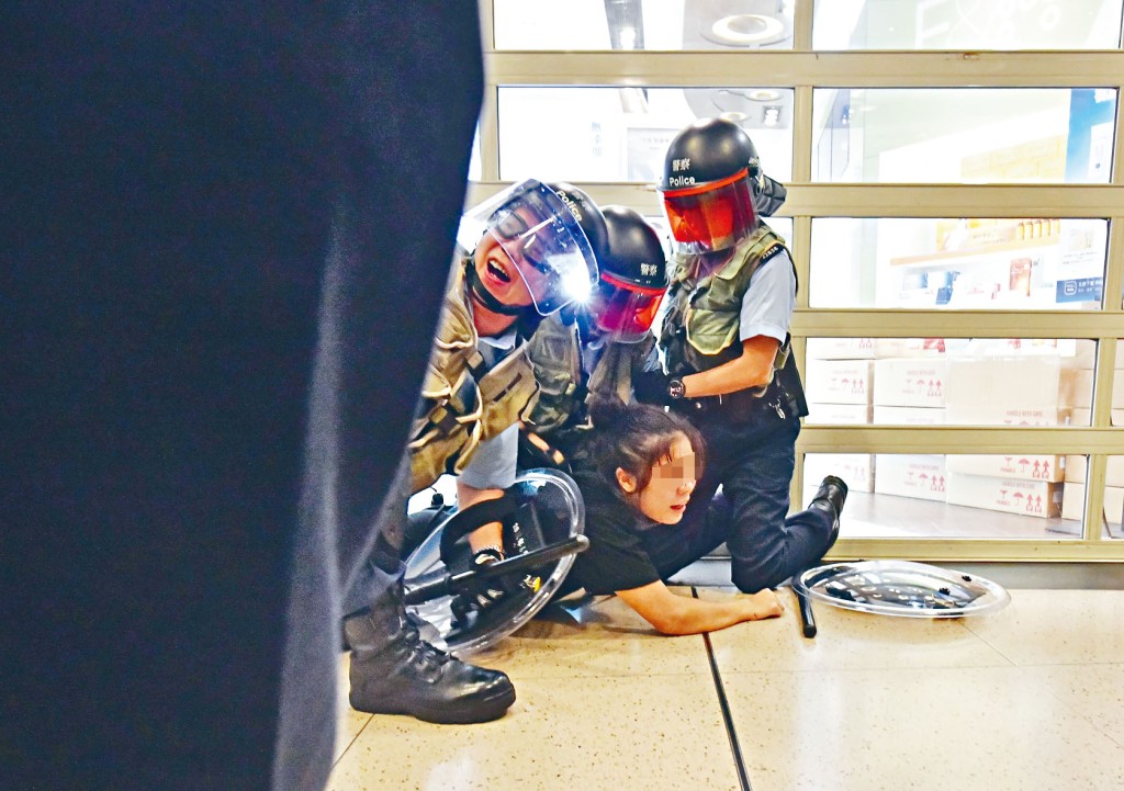 ■警方當日將涉非法集結少女制服壓倒地上。