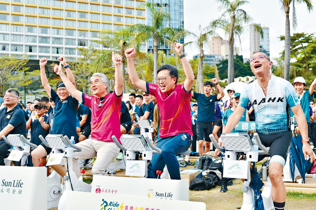 創新科技及工業局常任秘書長蔡傑銘（中）宣布活動成功衝破60萬公里大關，與善德基金會主席藍國慶（左）及機管局機場運行執行總監姚兆聰（右）振臂高呼。