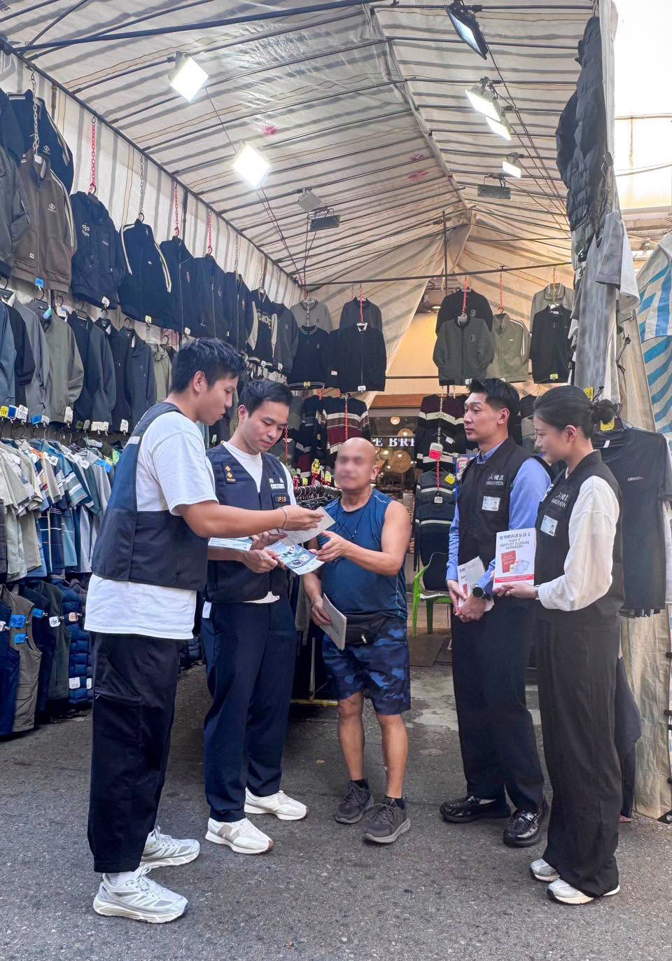 海關人員向商戶派發單張,提醒他們遵守《商品說明條例》,切勿售賣冒牌物品。香港海關FB圖片 海關人員向商戶派發單張,提醒他們遵守《商品說明條例》,切勿售賣冒牌物品。香港海關FB圖片