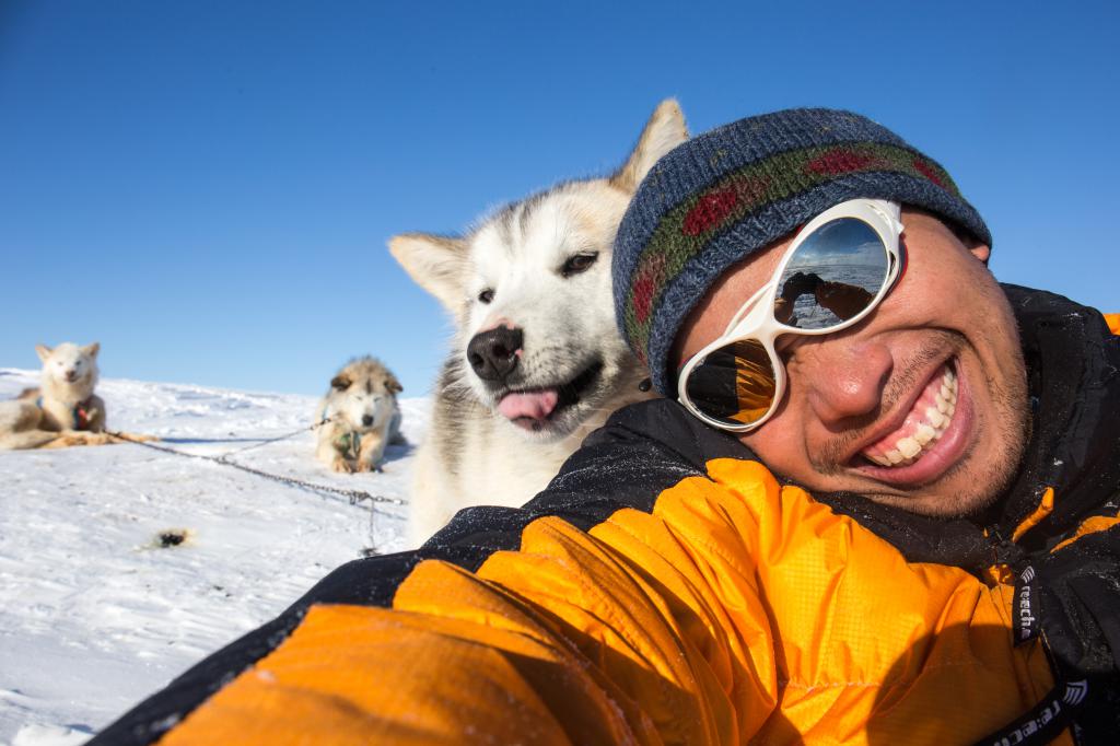 张伟贤喜爱大自然，他与拉动雪橇的雪橇犬合照。 受访者提供