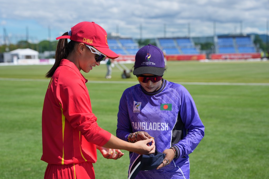 國家女子板球隊隊長朱明月（左）和孟加拉隊選手的合影。新華社