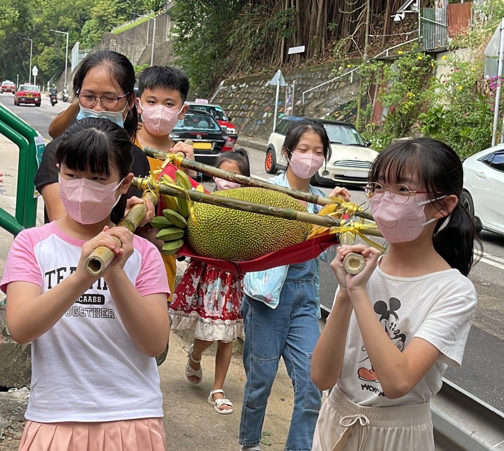 「大树菠萝文化节」开始前，村内小朋友按传统抬着大树菠萝进场。
