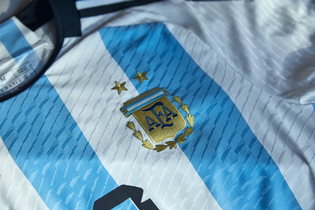 １）阿根廷 / 主場球衣： 阿根廷作為歷年世盃熱門隊伍，適逢球王美斯最後一次參戰，主場球衣以經典藍白作主色，同時亦把國旗與國徽之中的「五月太陽」圖案印於球衣後領內側位置，細節一絲不苟，店舖直指今年銷量比往年多一倍。Adidas圖片