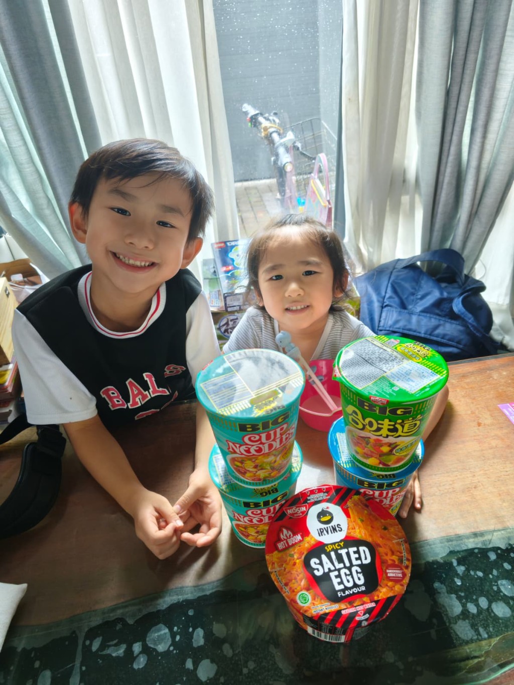 由于家中停电无法用电磁炉煮食，曹敏宝及一对子女吃杯面充饥。