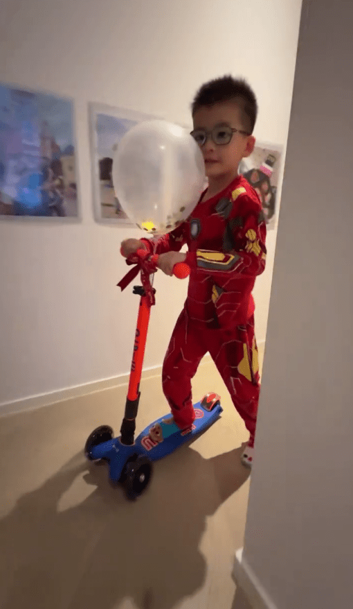 楊洛婷兒子在豪宅的走廊玩滑板車。