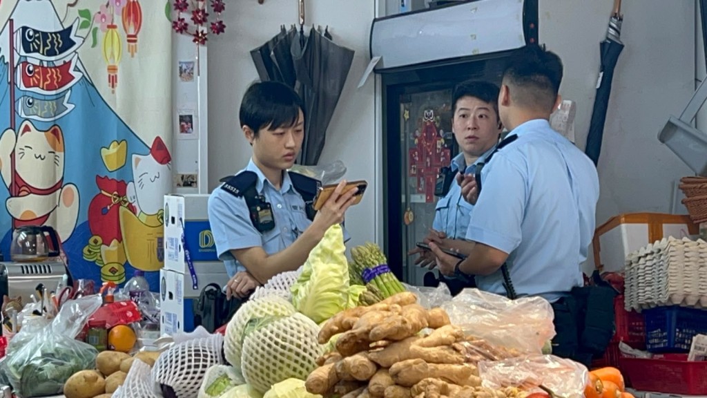 警員在蔬果店調查。 警員在蔬果店調查。
