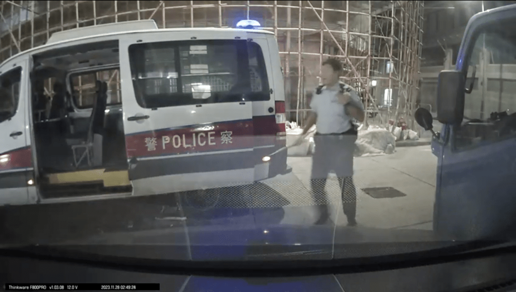 警員手持警棍欲截停可疑車輛。