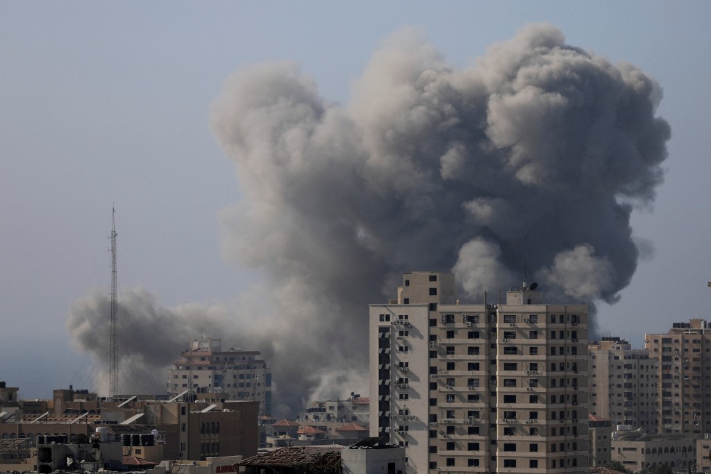 以軍持續空襲下，加沙城建築物中彈後冒出大量濃煙。路透社