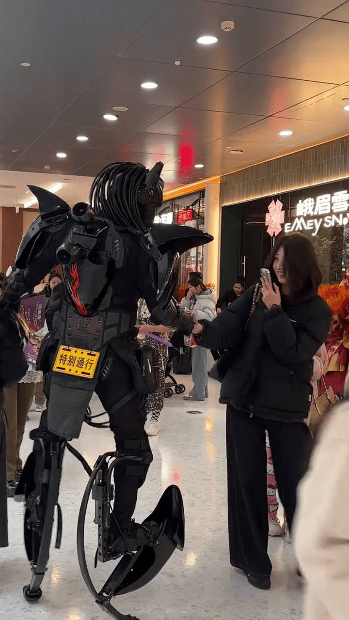 周高賽穿上機甲「戰衣」與民眾握手，令他倍感自豪。 抖音