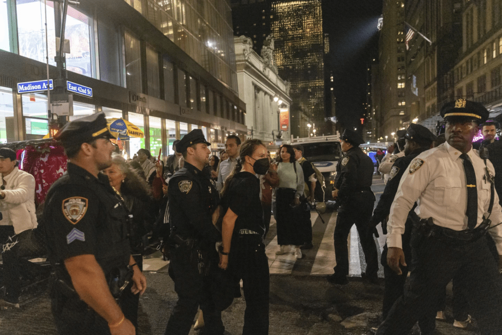 紐約警察局警官在中央大車站外帶走了一名被捕的示威者。 AP