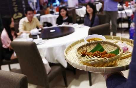 「螃蟹之家」餐厅推介配上家蟋蟀的沙嗲串烧，让食客试食。　路透社