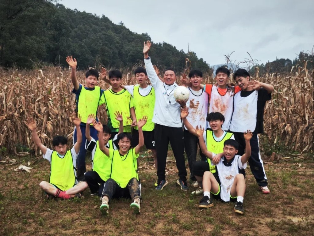 歐陽謙帶領學生用鋤頭在粟米田開出一個足球場。央視