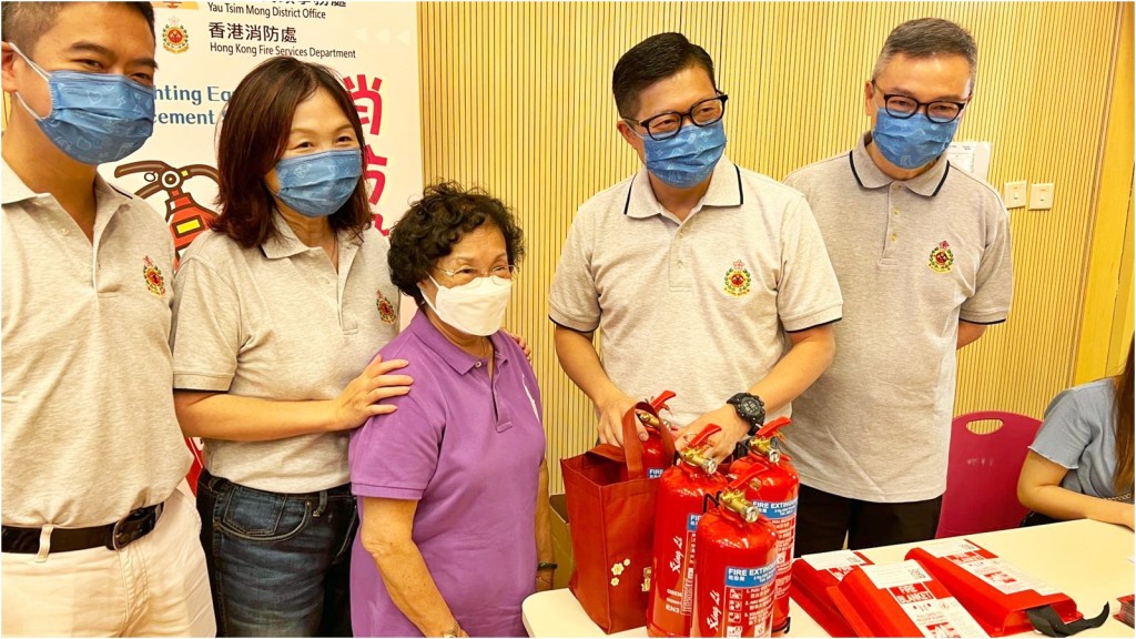 邓炳强（右二）等人为去年获发灭火筒及灭火毡的旧式单位业户更换已进行年检的消防设备。