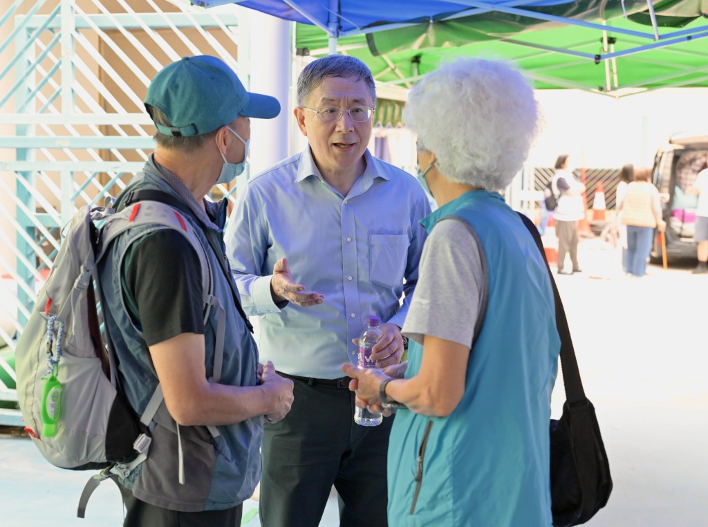 卓永興（中）與宏仁閣居民交談。