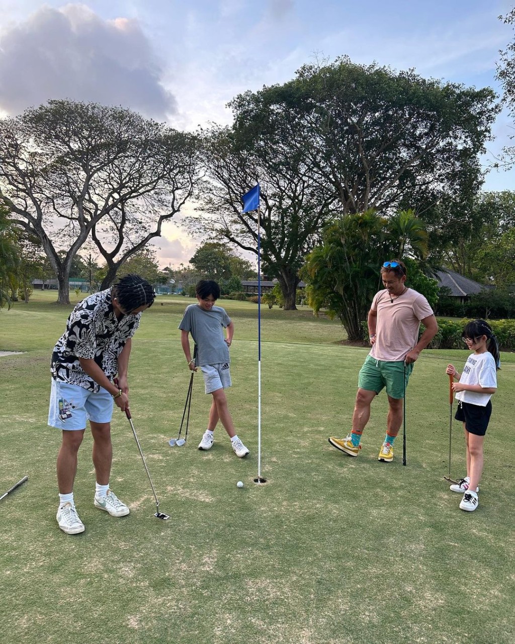 爸爸又化身教練，教子女玩高爾夫球。
