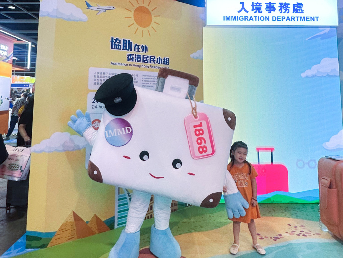 参观市民在展区与「协助在外香港居民小组」的吉祥物「阿邦」合照。
