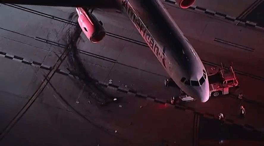 飞机与接驳车相撞后，地上留下了数条黑色轮痕。