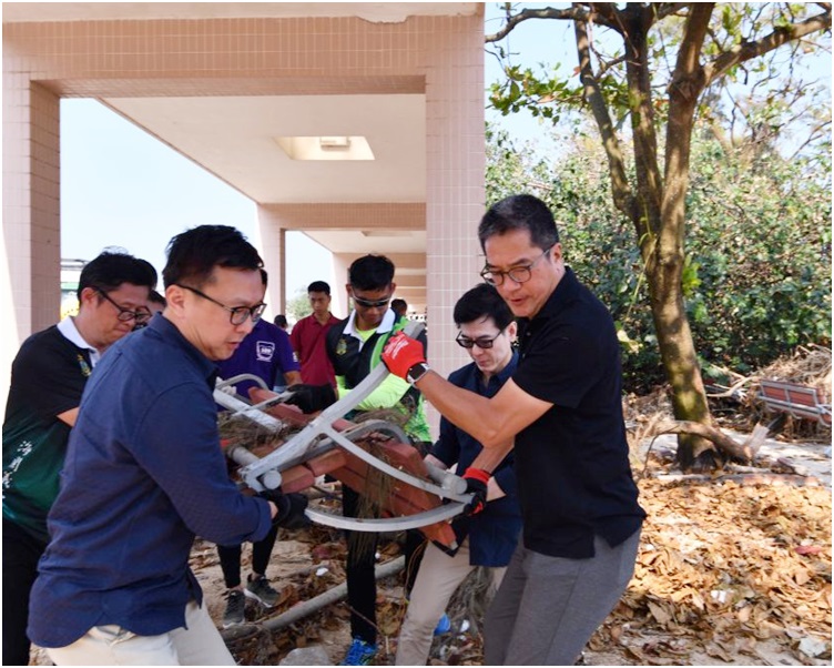 黃偉綸(右)與海關關長鄧以海(左)到石澳泳灘,清理泳灘上損毀的設施。