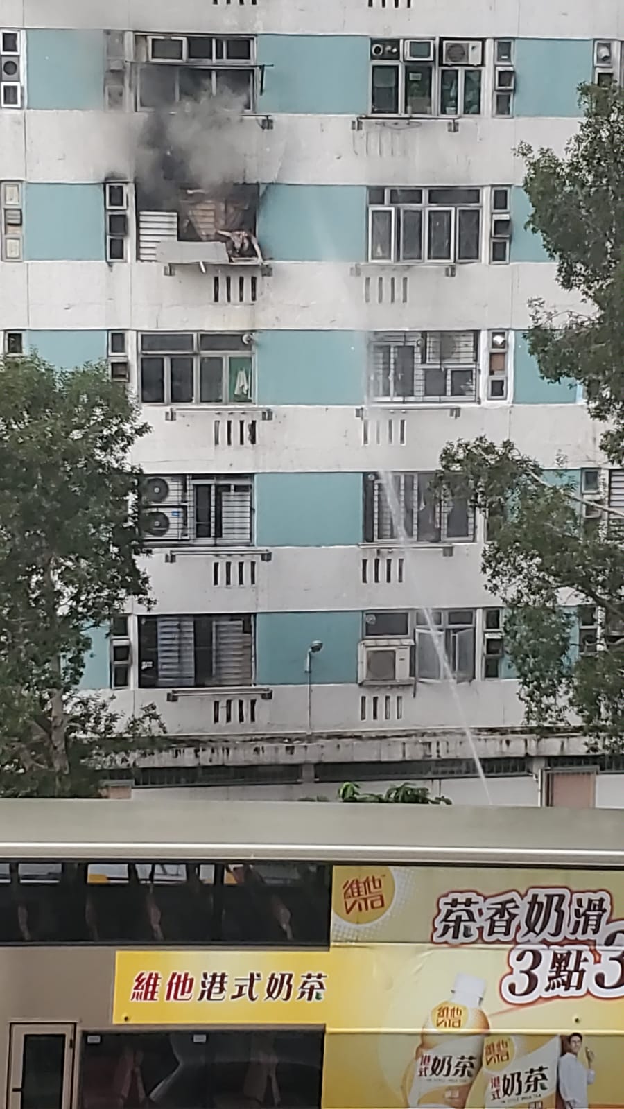 婦人危坐在窗口邊待救。圖:讀者提供
