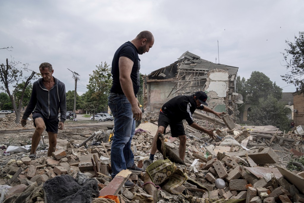 一個住宅區遭俄軍砲擊後居民在廢墟欲尋回有用物品。AP