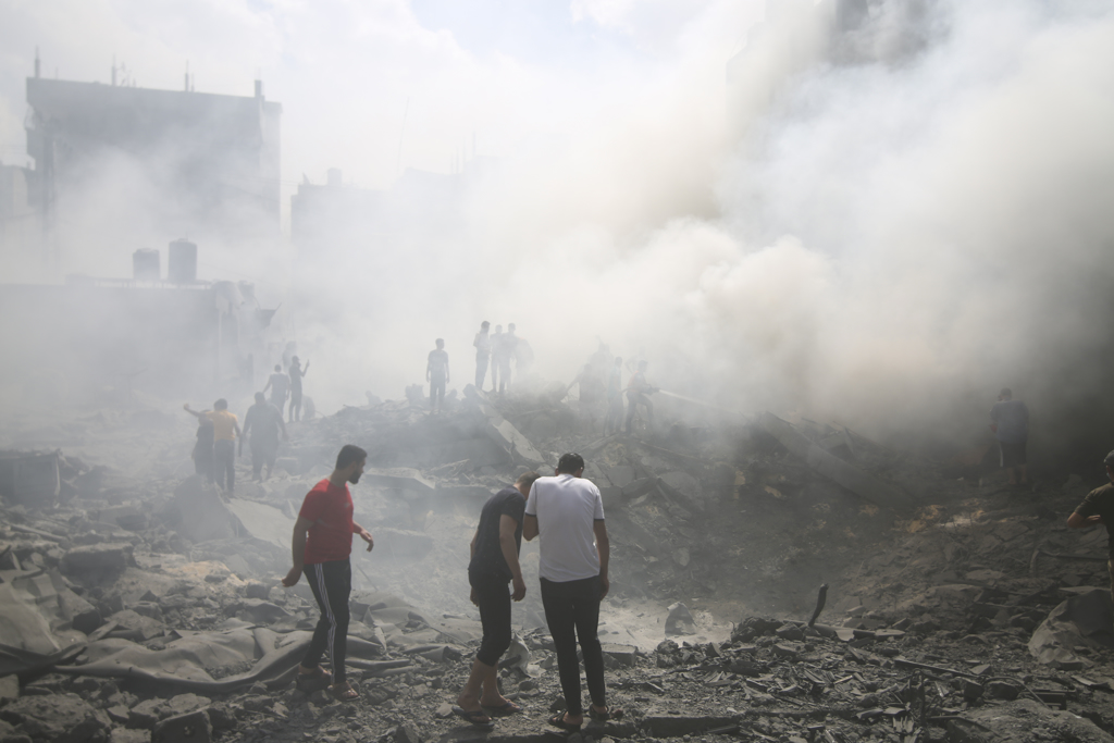 以色列空袭加沙南部难民营后，当地巴勒斯坦人四处寻找幸存者。美联社