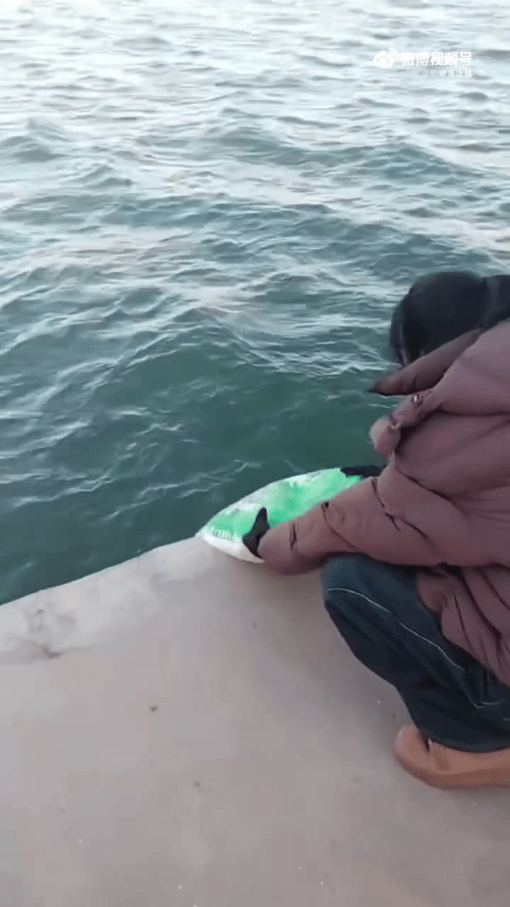 遼寧葫蘆島多人海邊「倒米」,口中唸唸有詞。 遼寧葫蘆島多人海邊「倒米」,口中唸唸有詞。