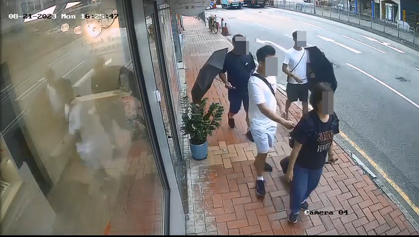 3名男子手持雨傘作遮掩，企圖打開前方女子的背囊盜竊。