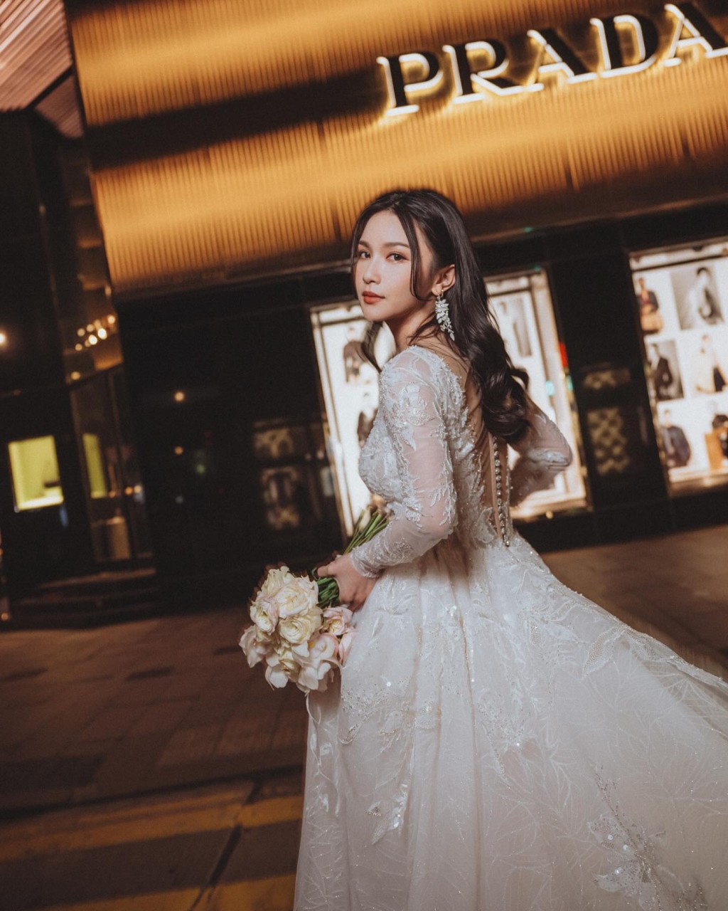 关枫馨穿白色长袖喱士拖尾婚纱，在疑似中环街头取景拍摄。