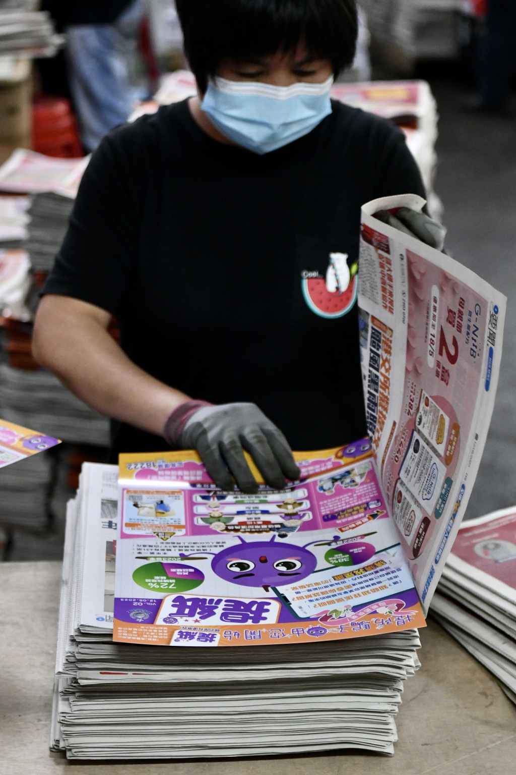 印制工人将「提纸」加进两份免费报纸内。