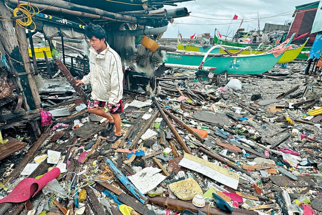 马尼拉大都会区一条村庄的岸边，遍布台风过境时冲上岸的杂物。