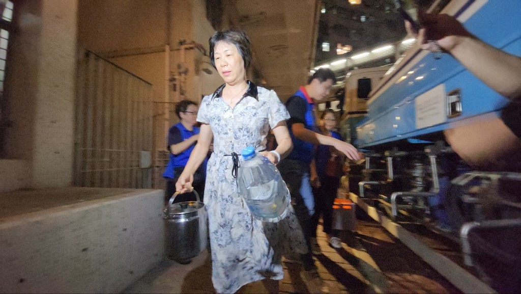 名居民帶同水桶到水車取水,秩序大致良好。黃文威攝 名居民帶同水桶到水車取水,秩序大致良好。黃文威攝