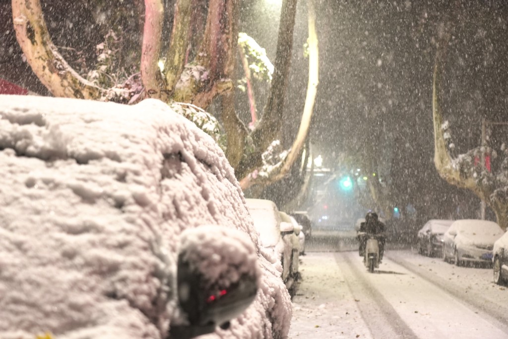 12月11日凌晨，市民在雪中骑行。 新华社