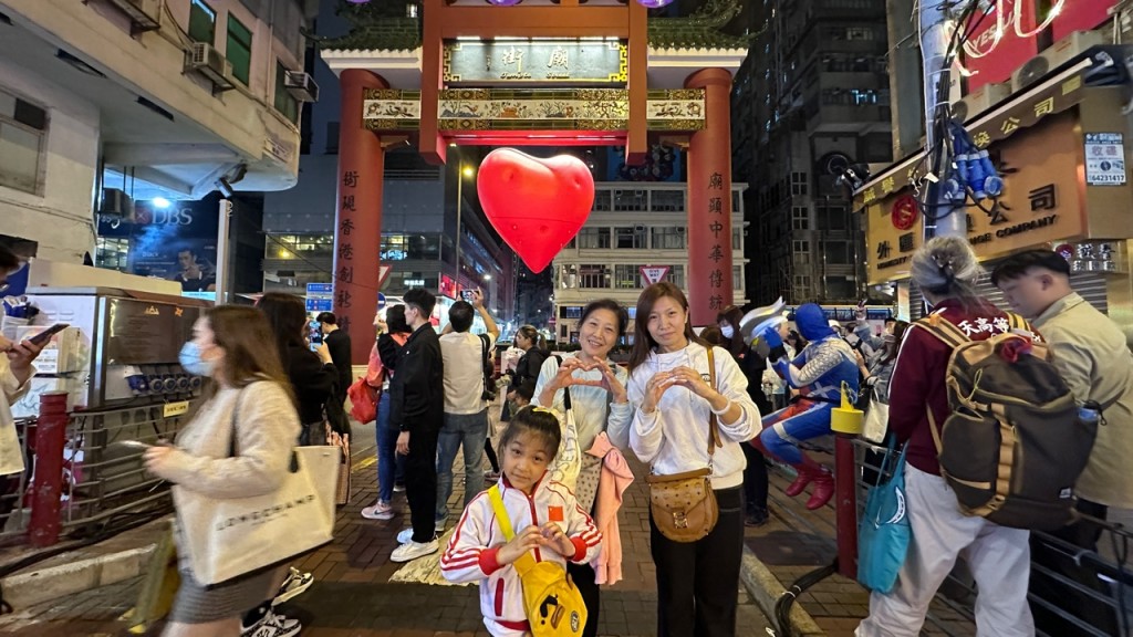 孟女士遊港數天在不同地方打卡，在廟街碰巧遇上紅心便拍照留念，更笑稱「在香港每日都開心快樂！」